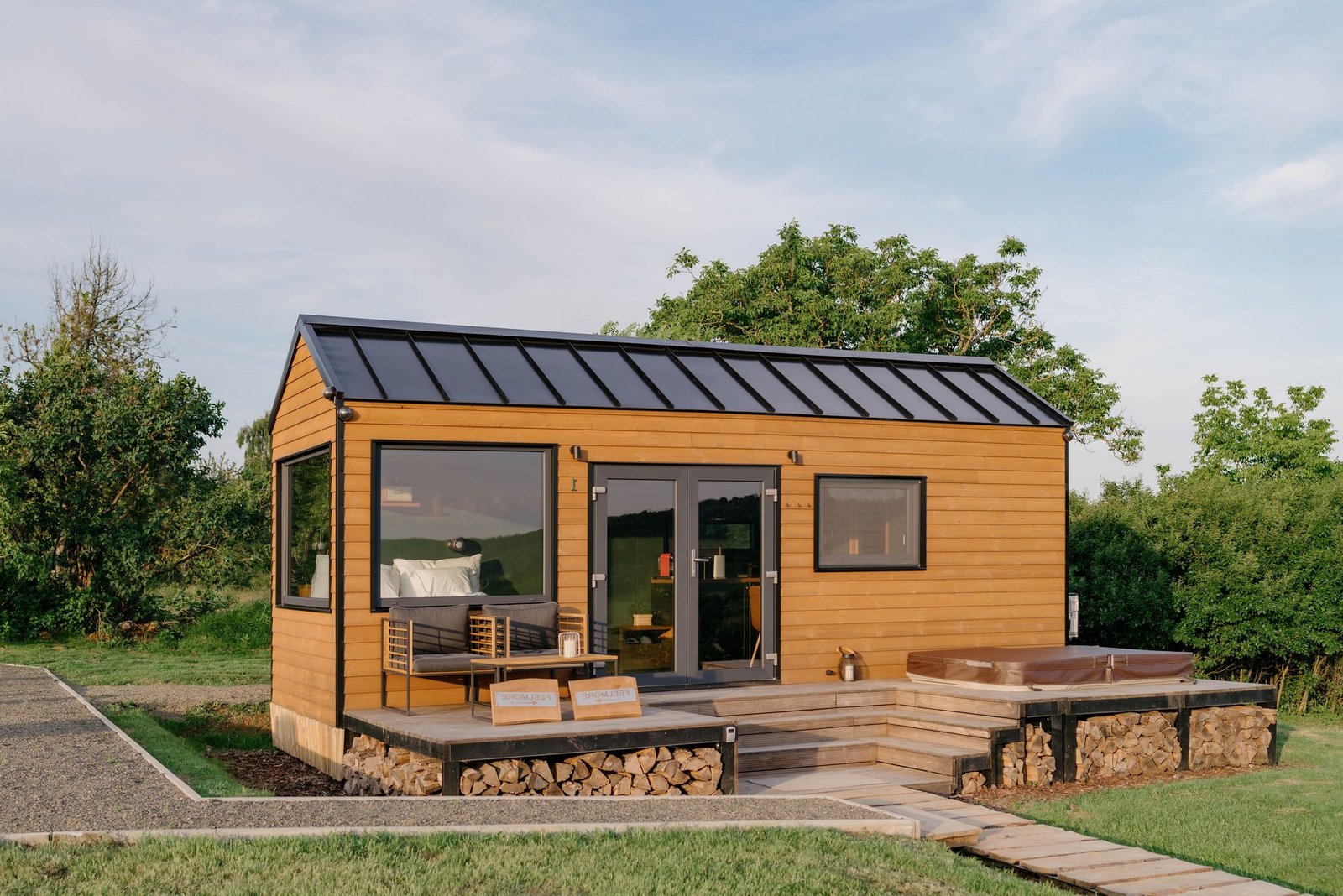 Malý moderní dům s terasou a vířivkou.