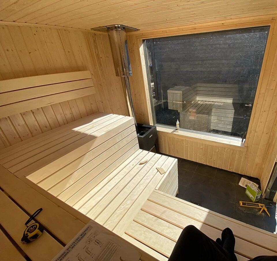 Moderní interiér sauny ze světlého dřeva s výhledem.