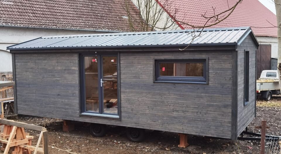 Mobilní dům se šedou fasádou na kolech