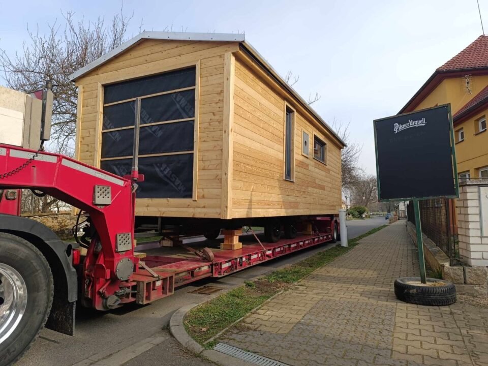 Dřevěný domek na nákladním voze.