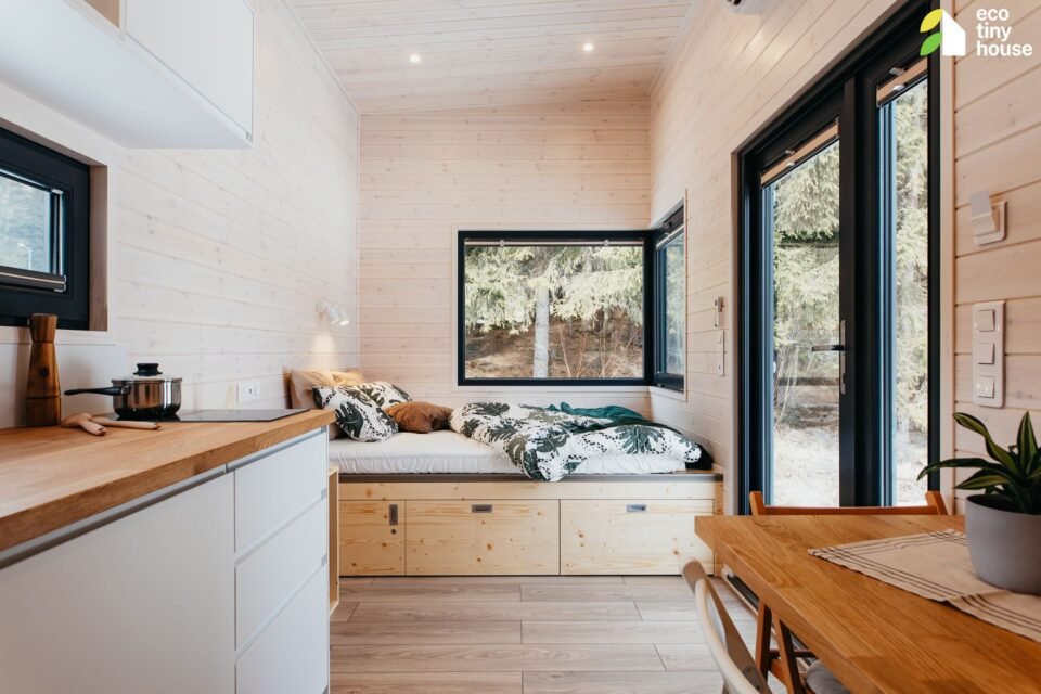 Mal&yacute; dřevěn&yacute; interi&eacute;r s v&yacute;hledem do lesa.